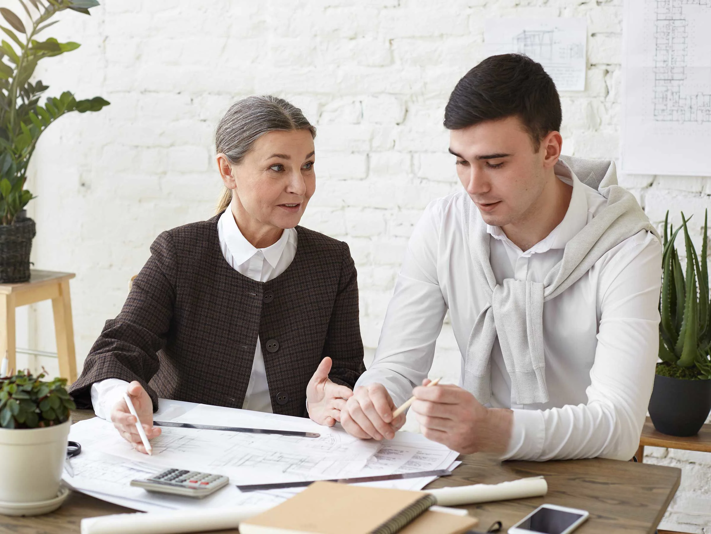 An woman teaching a young man